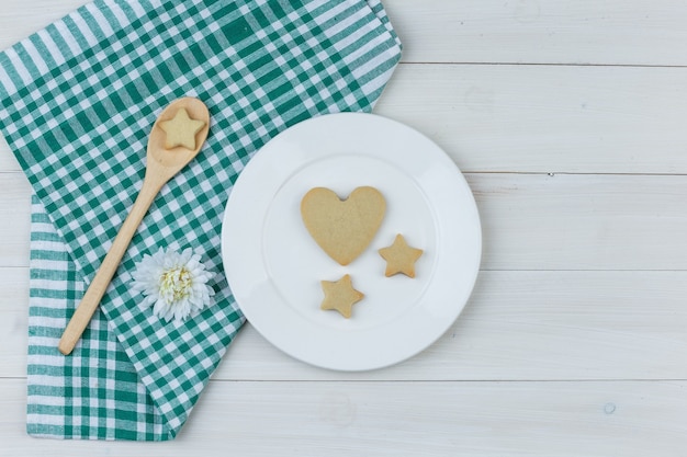 Niektóre Ciasteczka Z Kwiatem W Talerz I Drewnianą łyżką Na Tle Ręcznik Drewniany I Kuchenny, Leżał Płasko.