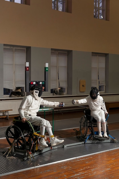 Niepełnosprawni szermierze w specjalnym sprzęcie walczący na wózkach inwalidzkich