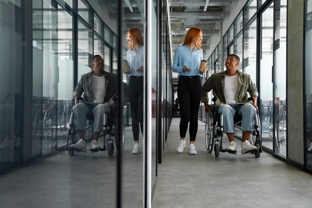 Niepełnosprawny mężczyzna na wózku inwalidzkim pracujący w swojej pracy biurowej