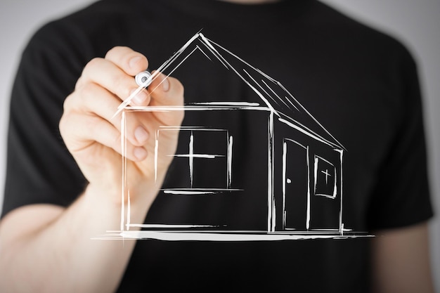 Nieruchomości, technologia i zakwaterowanie - obraz mężczyzny rysującego dom na wirtualnym ekranie