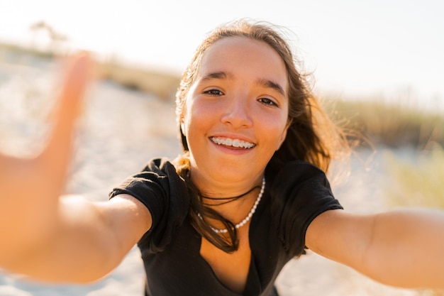 Niesamowita dziewczyna bawi się i robi autoportret przez aparat na słonecznej plaży