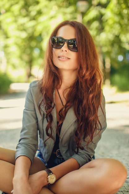 Bezpłatne zdjęcie niesamowita młoda kobieta w okularach przeciwsłonecznych pozowanie w wiosennym parku.