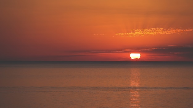 Niesamowite ujęcie pięknego krajobrazu morskiego na pomarańczowym zachodzie słońca