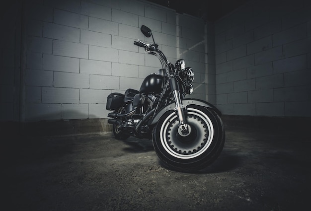 Niesamowity, nowy motocykl stoi na ciemnym podziemnym parkingu.