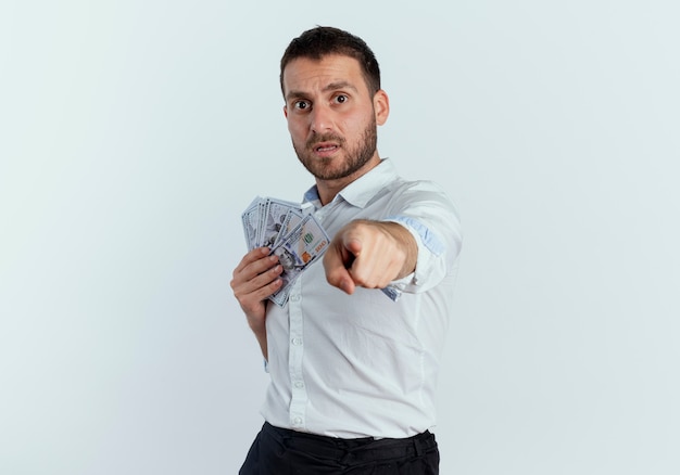 Bezpłatne zdjęcie niespokojny przystojny mężczyzna trzyma pieniądze i punkty na białym tle na białej ścianie