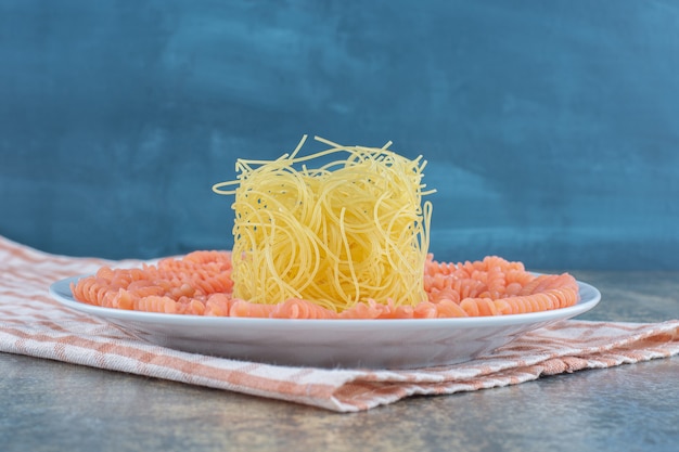 Nieugotowane Spaghetti I Makaron Fusilli W Misce Na Ręczniku, Na Marmurowej Powierzchni.