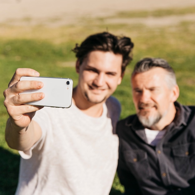 Niewyraźne ojciec i syn biorąc selfie