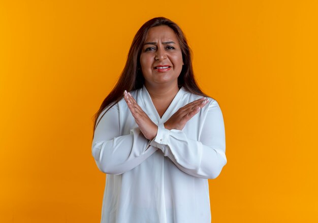 Niezadowolona przypadkowa kaukaska kobieta w średnim wieku pokazująca gest nie izolowany na żółtej ścianie