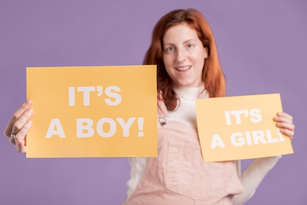 Niski kąt kobiety w ciąży, trzymając papier płci dziecka