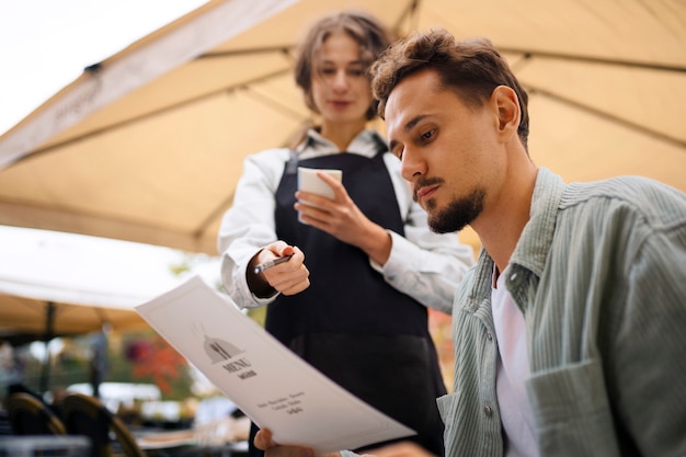 Bezpłatne zdjęcie niski kąt mężczyzna trzyma menu