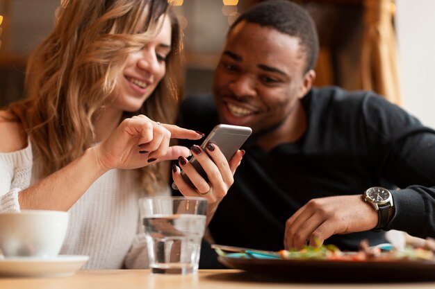 Niski kąt przyjaciół patrząc na telefon