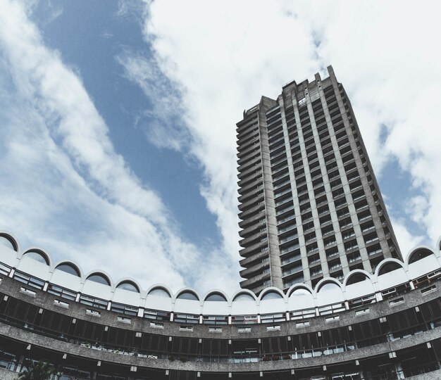 Niski kąt strzału Barbican Centre w Londynie z zachmurzonym błękitnym niebem