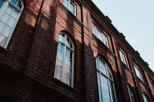 Bezpłatne zdjęcie niski kąt strzału brązowy betonowy budynek z łukowymi oknami