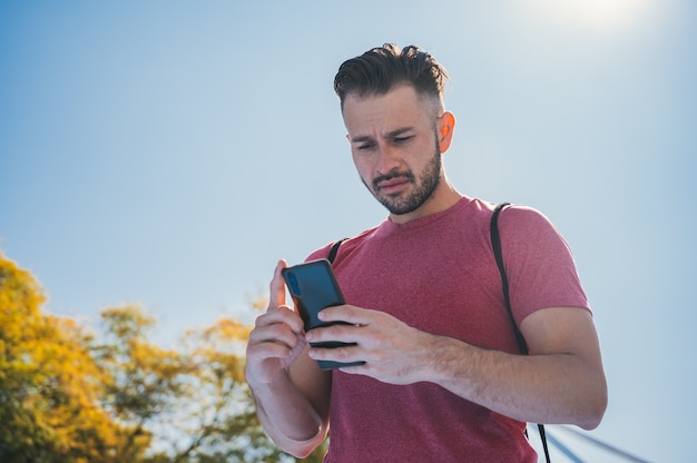 Niski Kąt Strzału Młodego Mężczyzny Sprawdzającego Swój Telefon Przed Treningiem