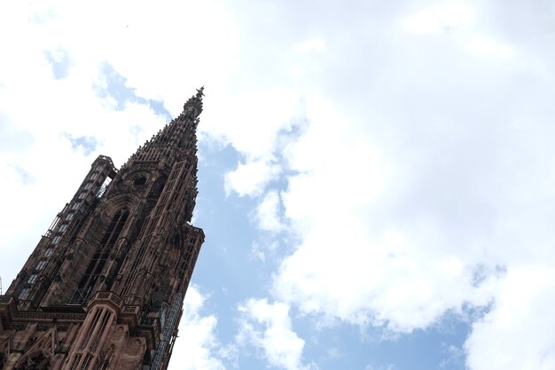Niski kąt strzału słynnej katedry Notre Dame w Strasburgu pod zachmurzonym niebem