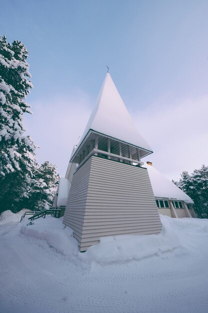 Niski kąt strzału wieży kaplicy pokrytej grubym śniegiem w zimie