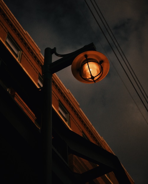 Bezpłatne zdjęcie niski kąt strzału zardzewiałe lampy uliczne na szarym niebie