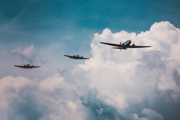Niski kąt ujęcia szeregu samolotów przygotowujących pokaz lotniczy pod zapierającym dech w piersiach pochmurnym niebem