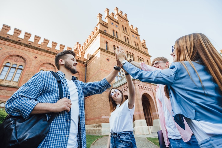 Bezpłatny plik Zdjęcie niski kąt wesoły zespół uczniów zdał test przygotowując wszystkich razem.
