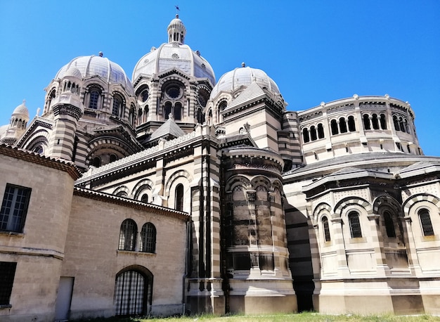 Niski kąt widzenia katedry w Marsylii w słońcu i błękitne niebo we Francji