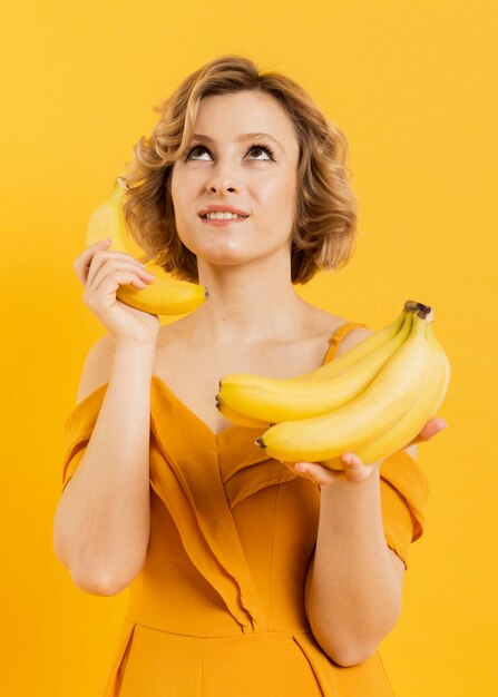 Niskiego kąta kobieta używa banana jako wisząca ozdoba