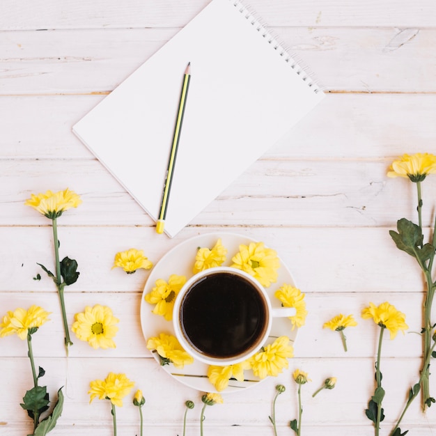 Bezpłatne zdjęcie notatnik i kwiaty z kawą