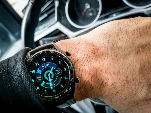 Nowoczesny czarny zegarek na nadgarstku mężczyzny siedzącego w samochodzie
