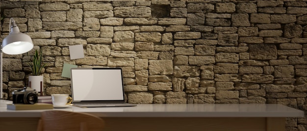 Nowoczesny loft w stylu vintage z makietą laptopa i miejscem na kopię na biurku nad kamienną ścianą
