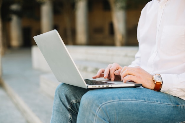 Nowożytny biznesmen używa laptop outdoors