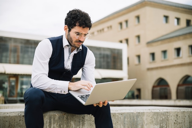 Nowożytny biznesmen używa laptop outdoors