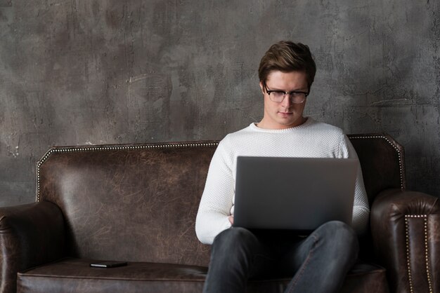 Bezpłatne zdjęcie nowożytny mężczyzna pracuje na laptopie z kopii przestrzenią