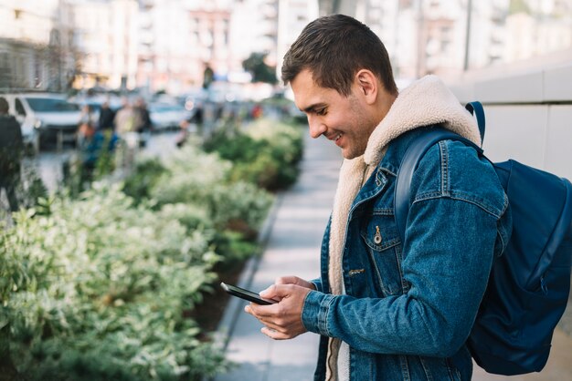 Nowożytny mężczyzna używa smartphone w mieście