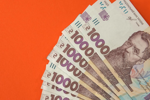 Nowy banknot 1000 roku 2020, ukraińskie pieniądze uah na pomarańczowym tle. zapisz koncepcję.