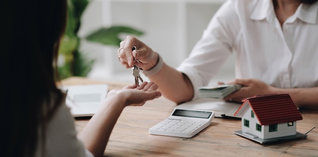 Nowy właściciel otrzymuje łańcuch kluczy do domu od pośrednika w obrocie nieruchomościami po wpłaceniu kaucji. pośrednik i klient, inwestowanie w nieruchomości.