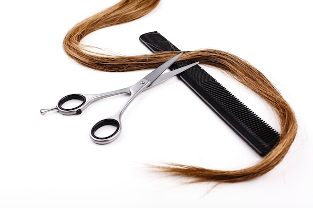 Nożyczki i grzebienie do cięcia włosów i leczenia leżą na białym stole