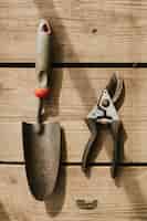 Bezpłatne zdjęcie nożyczki ogrodnicze i kielnia na drewnianej płaskownicy