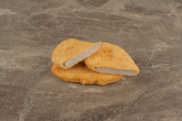 Nuggetsy z kurczaka na marmurowej powierzchni.