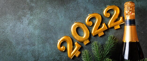 Numer 2022 z butelką szampana i dekoracją. szczęśliwego nowego roku i świąteczna koncepcja. widok z góry poziomy, lato. nowy rok po prostu. boże narodzenie na płasko. nowy rok 2022. koncepcja nowego roku.