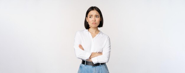 Obraz smutnej dziewczyny biurowej azjatyckiej kobiety dąsającej się i marszczącej brwi, rozczarowanej stojącej zdenerwowanej i zmartwionej