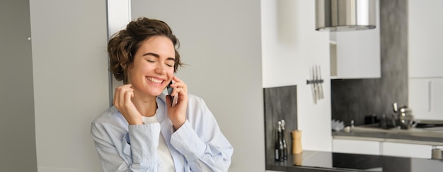Obraz szczęśliwej kobiety rozmawiającej przez telefon komórkowy, rozmawiającej za pomocą smartfona, śmiejącej się i uśmiechającej się
