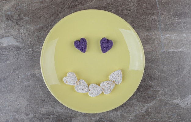 Bezpłatne zdjęcie obraz uśmiechu zrobiony z ciastek na talerzu na marmurowej powierzchni