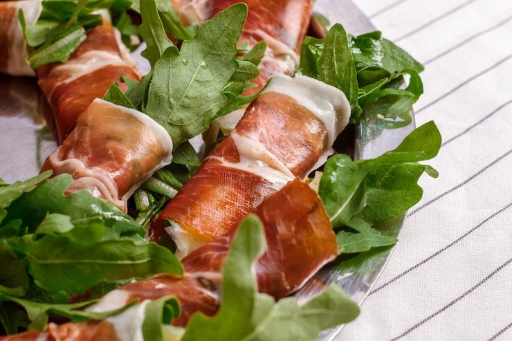 Bezpłatny plik Zdjęcie obrazek bekonowe rolki z arugula na biel ścianie.