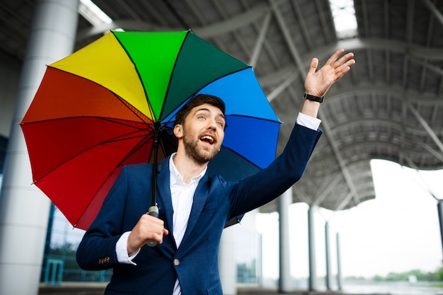 Obrazek trzyma biznesmena falowania parasolową rękę młody biznesmen