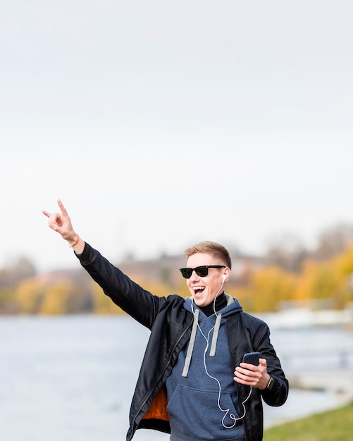 Bezpłatne zdjęcie obsługuje słuchanie muzyka na słuchawkach outdoors z kopii przestrzenią