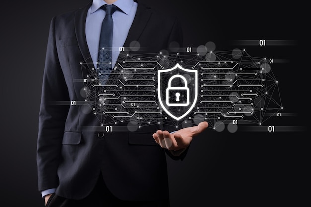 Ochrona komputera bezpieczeństwa sieci i bezpieczne pojęcie danych, biznesmen posiadający ikonę ochrony tarczy. symbol kłódki, koncepcja dotycząca bezpieczeństwa, cyberbezpieczeństwa i ochrony przed zagrożeniami