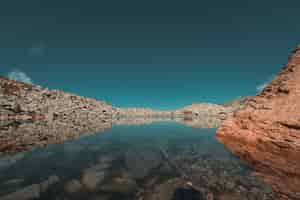 Bezpłatne zdjęcie odbicia jeziora polodowcowego w górach w sezonie jesiennym