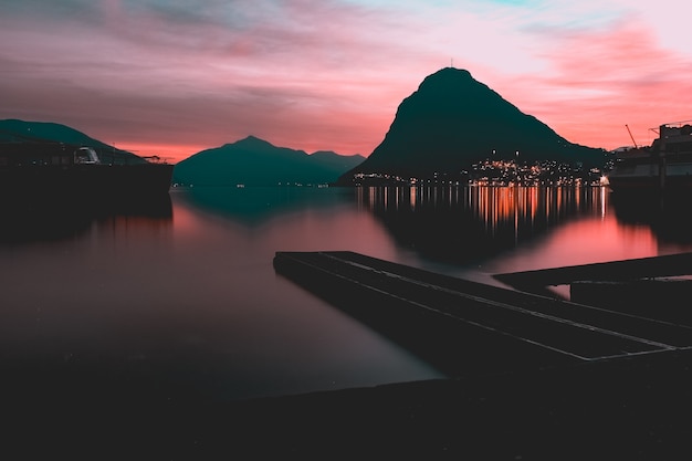 Odbicie świateł i góry w jeziorze uchwycone w Parco Ciani, Lugano, Szwajcaria
