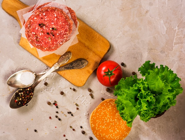 Odgórnego widoku hamburgeru surowy mięso na drewnianym stole