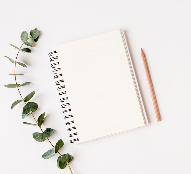 Bezpłatny plik Zdjęcie odgórnego widoku notepad z zielonym liścia pojęciem