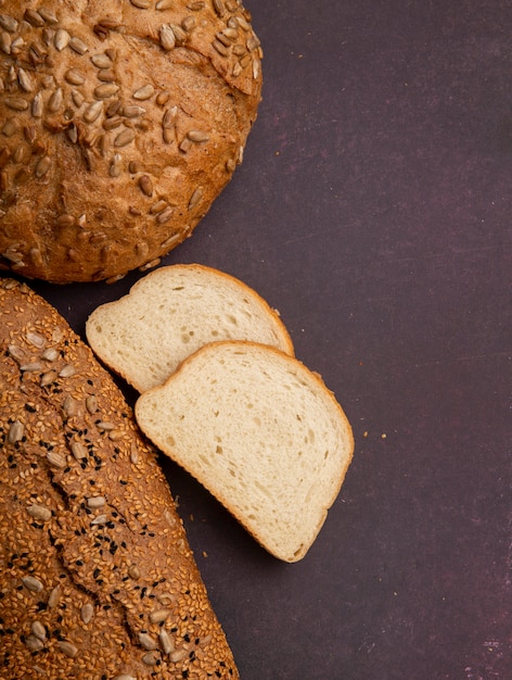 Odgórny widok białego chleba plasterki z cob i baguette na tle z kopii przestrzenią po lewej stronie i wałkoni się